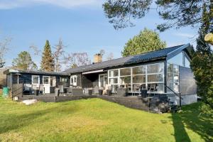 a home with a large deck and a house at Cozy Cottage Only 500 M From The Sea in Gilleleje