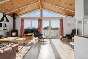 a living room with a vaulted ceiling and a large window at Pool House Close To The Coast in Vestervig