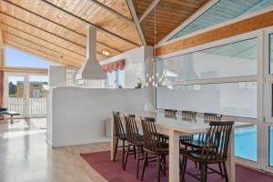 a dining room with a table and chairs at Pool House Close To The Coast in Vestervig