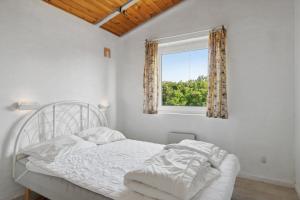 a white bedroom with a bed and a window at Pool House Close To The Coast in Vestervig +20 photos