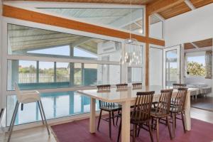 a dining room with a table and chairs and a pool at Pool House Close To The Coast in Vestervig