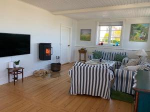 a living room with two couches and a flat screen tv at Cottage With Breathtaking Sea And Cliff Views in Allinge