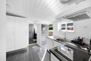 a kitchen with white cabinets and a sink at Cottage With Breathtaking Sea And Cliff Views in Allinge