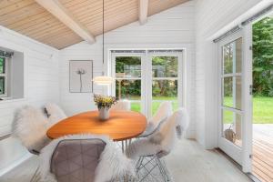 a dining room with a wooden table and chairs at Summer Cottage With Jacuzzi And Sauna in Fakse Ladeplads