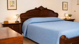 a bedroom with a large bed with a blue blanket at Casa Vacanze Agriturismo BioMele in Policoro