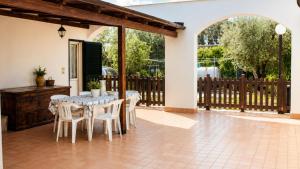 a patio with a table and chairs and a fence at Casa Vacanze Agriturismo BioMele in Policoro