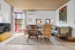 a living room with a table and chairs and a couch at Spacious Cottage Surrounded By Forest in Mesinge