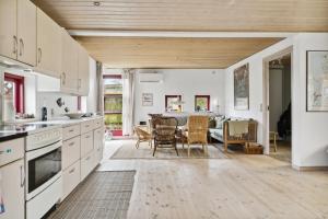 a kitchen with white cabinets and a dining room at Spacious Cottage Surrounded By Forest in Mesinge