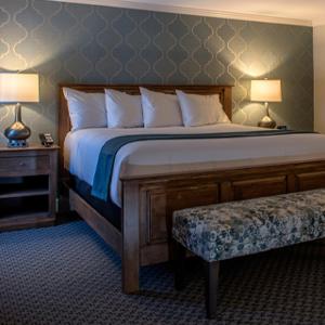 a bedroom with a bed and a bench and two lamps at The Spa at Norwich Inn in Norwich +13 photos