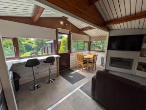 a living room with a television and a table with chairs at Cabin Aelwyd Snowdonia in Trawsfynydd