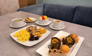 a table with two plates of food and two cups of coffee at Cabecera Country Hotel in Bucaramanga