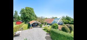 a house with a red barn and a garden at Cozy Holiday Home With Character in Nakskov