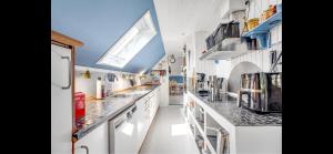 a large kitchen with white cabinets and a blue ceiling at Cozy Holiday Home With Character in Nakskov +26 photos