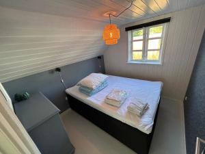 a small bed in a small room with a window at Cozy Holiday Home With Character in Nakskov