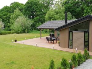 a gazebo in a garden with a table at Charming Cottage In Fjellerup With Indoor Spa in Glesborg