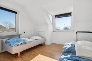 a bedroom with two beds and two windows at House For 40 People Near Thy in Gettrup