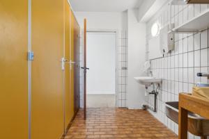 a bathroom with a yellow door and a sink at House For 40 People Near Thy in Gettrup +16 photos