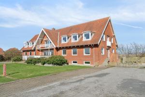 a large brick house with a red roof at House For 40 People Near Thy in Gettrup