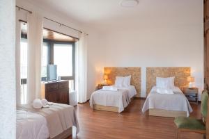 a hotel room with two beds and a television at Estoril Guest Palace in Estoril +71 photos