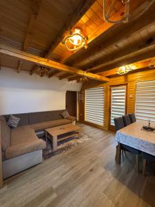 a living room with a couch and a table at Vlasic Odmor - Villa Krajina IV & jacuzzi in Vlasic