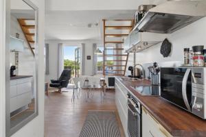 a kitchen with a counter and a dining room at Holiday Apartment For 4 With Shared Pool in Åkirkeby