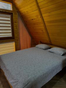 a bedroom with a bed in a wooden room at Vlasic Odmor - Villa Krajina IV & jacuzzi in Vlasic