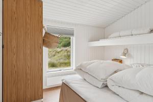 a bedroom with a bed and a window at Scenic Holiday Home In Bratten in Jerup