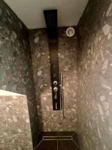 a bathroom with a shower with a stone wall at infinity sky stay in episkopi-heraklion