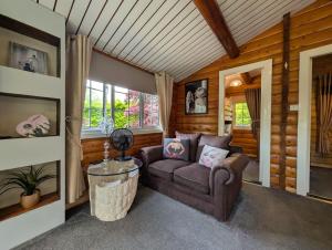 a living room with a couch and a table at Cabin Aelwyd Snowdonia in Trawsfynydd