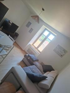 a living room with a couch and a window at Au Bien-hêtre in Granges-sur-Vologne