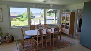 a dining room with a table and chairs and a window at Cozy Summerhouse With Spectacular Views in Ølsted