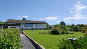 a house with a garden in front of it at Cozy Summerhouse With Spectacular Views in Ølsted