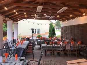 an outdoor patio with tables and chairs and lights at Belvárdi Fogadó in Belvárdgyula