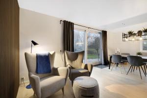 ein Wohnzimmer mit Stühlen und ein Esszimmer in der Unterkunft Schönes Neu Renoviertes Sommerhaus Am Meer in Frørup + 9 Fotos