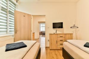 a bedroom with two beds and a television on a dresser at Hostel u Arény in Ostrava