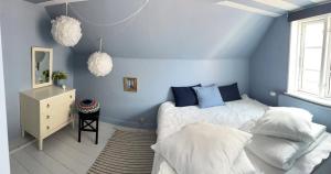 a blue bedroom with a bed and a mirror at Tordenskjoldet in Marstal