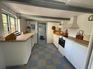 a kitchen with white cabinets and a checkered floor at Tordenskjoldet in Marstal +11 photos