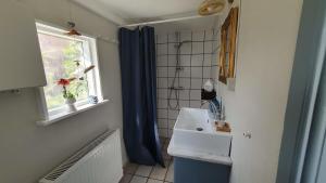 a bathroom with a sink and a window at Tordenskjoldet in Marstal