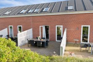 a brick building with a table and chairs on a patio at Summer House On Beautiful Rømø in Sønderby