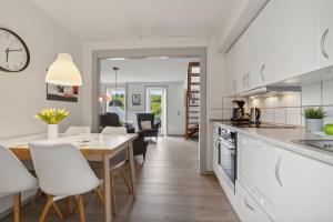 a kitchen and dining room with a table and chairs at Summer House On Beautiful Rømø in Sønderby