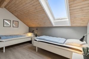 two beds in a room with a skylight at Summer House On Beautiful Rømø in Sønderby