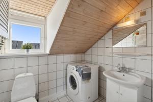 a bathroom with a washing machine and a sink at Summer House On Beautiful Rømø in Sønderby