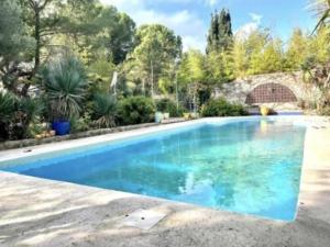 a swimming pool with blue water in a yard at La Tour in Béziers