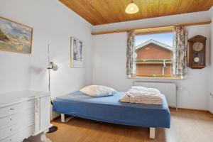 a small bedroom with a blue bed and a window at Cozy Holiday Home In Thisted in Thisted