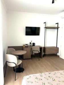 a room with a table and chairs and a tv at I Cordari B&B in Vieste
