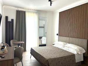 a bedroom with a bed and a table and a desk at I Cordari B&B in Vieste