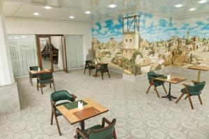 a restaurant with tables and chairs and a mural at Safia Plaza Hotel in Bukhara
