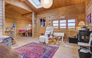 a living room with wooden walls and wooden flooring at Cozy Log Cabin With A Panoramic View in Glesborg