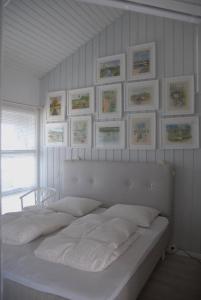 a bedroom with a white bed with pictures on the wall at Outstanding Close To Nice Beachh in Karrebæksminde