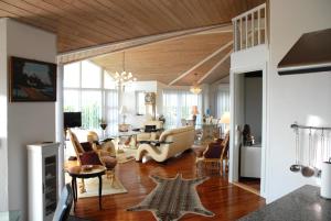 a living room with wooden ceilings and a living room with furniture at Outstanding Close To Nice Beachh in Karrebæksminde